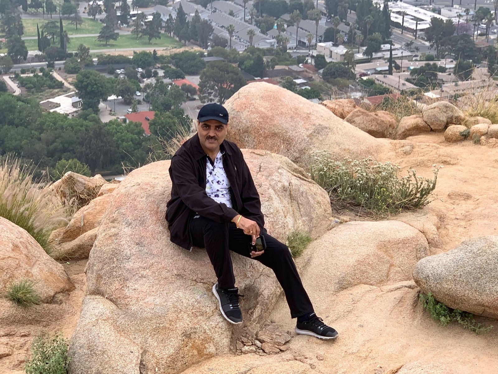 Gaurav Ghulati sitting on large rocks during an outdoor hike.